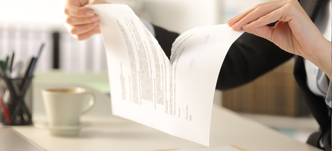 Persona rompiendo un documento en dos